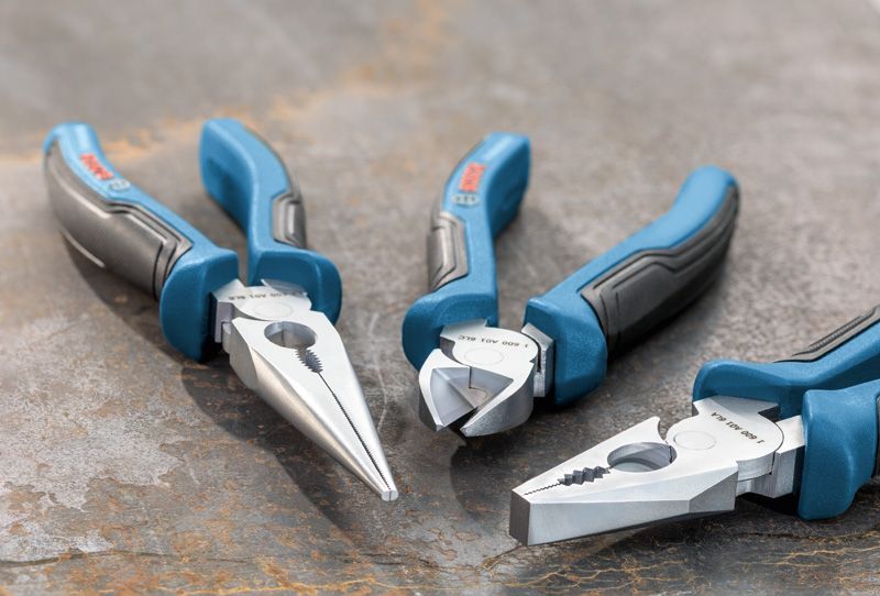 Three-piece plier set with blue and black handles arranged on a metal surface.
