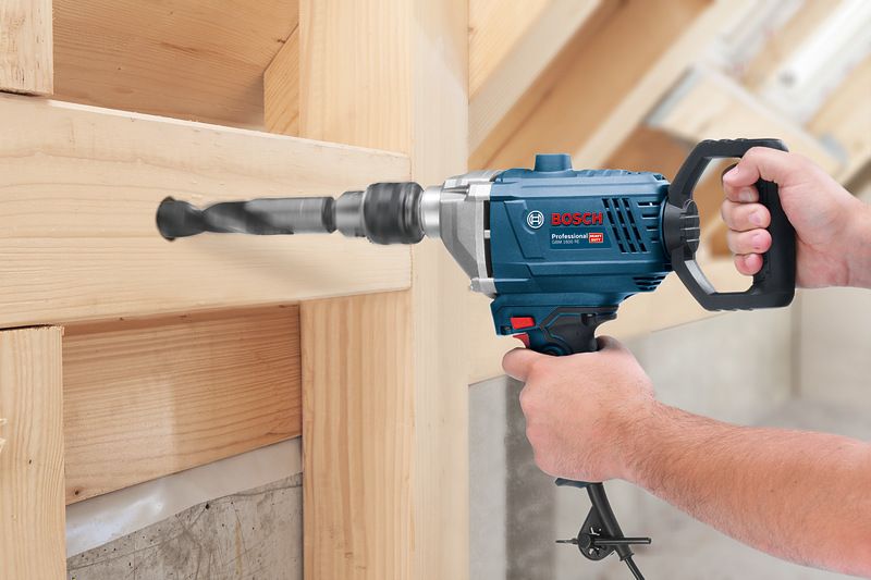 Person drilling a hole in a wooden beam using an angle drill.