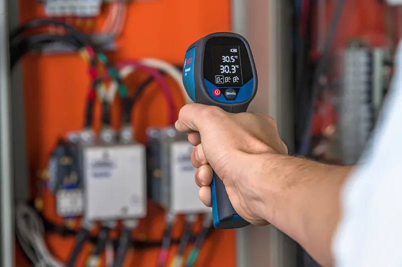 Infrared thermometer checks panel.