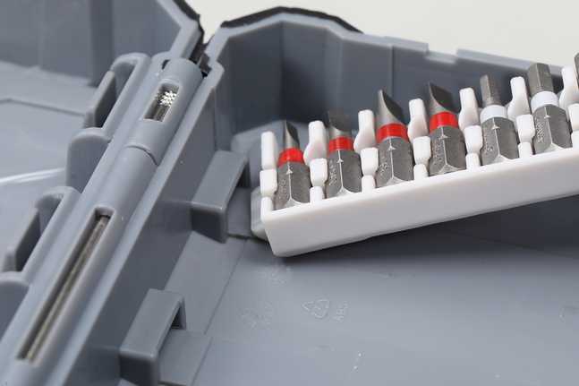 Assorted screwdriver bits organized in a plastic holder inside a gray tool case.