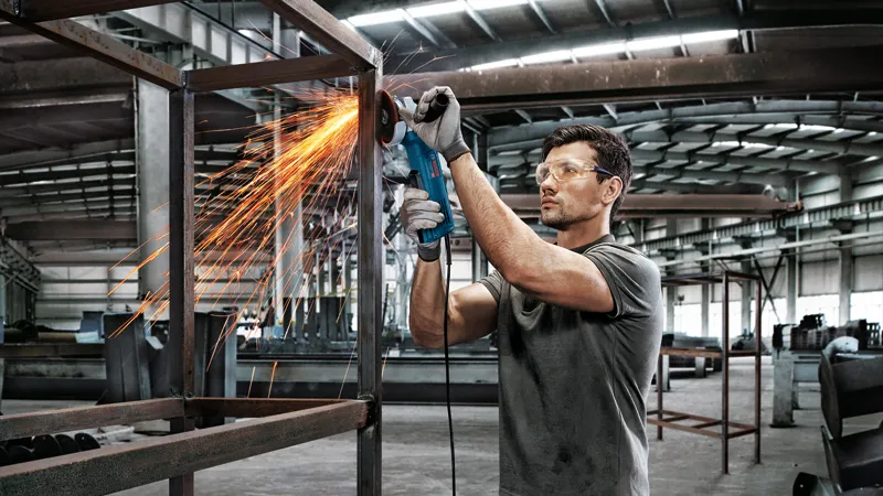 Man grinding metal frame.