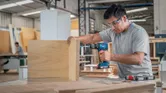 Man drilling wooden boards.