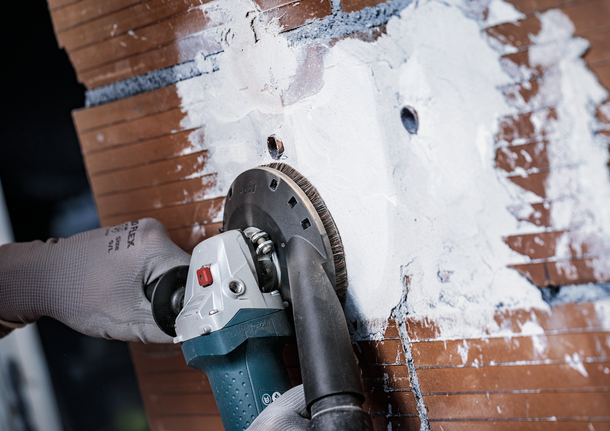 Bosch diamond grinding disc smoothing wall surface.