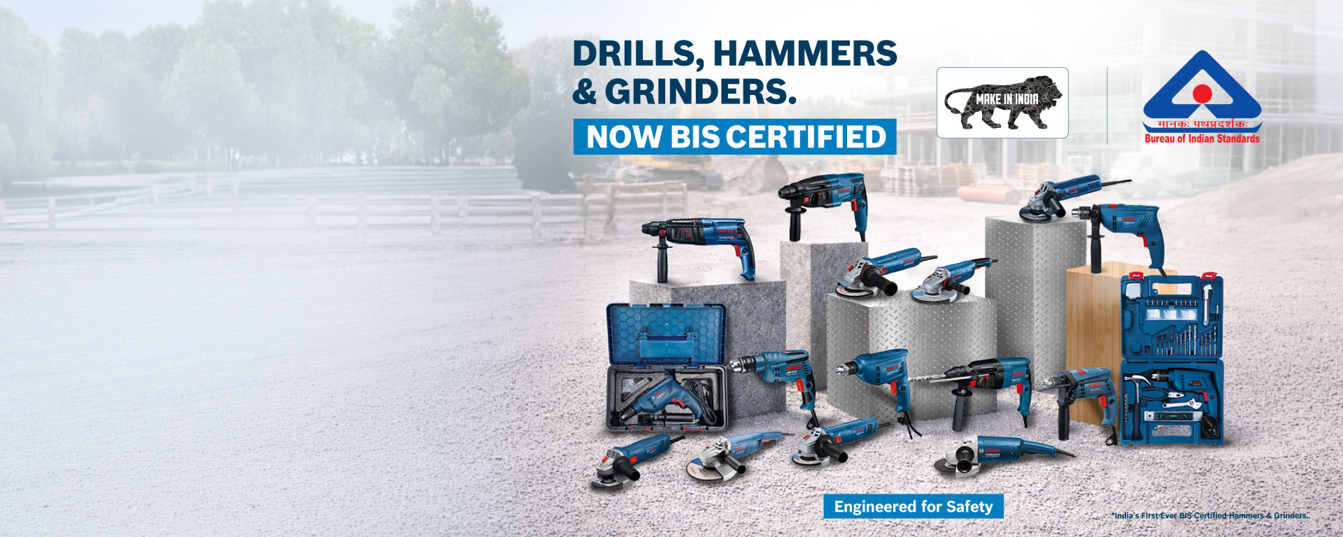 A collection of Bosch Professional tools including drills, hammers, and grinders set on gray surfaces outdoors.