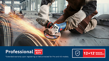 A worker in a brown apron uses a blue Bosch Professional angle grinder on a metal surface, sparks flying.